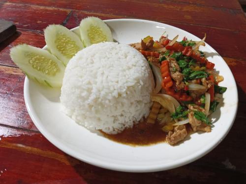 a plate of rice and meat and vegetables on a table at Song Lao Guesthouse in Thakhek