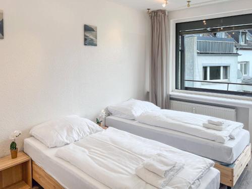twee bedden in een kamer met een raam bij T&K Apartments - Krefeld Zentrum - 1 and 2 room Apartment 20min to Fair DUS in Krefeld