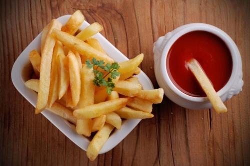 a plate of french fries and a cup of ketchup at Song Lao Guesthouse in Thakhek