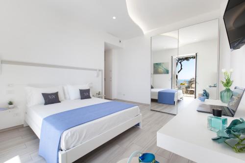 a bedroom with a large bed and a mirror at AMORE RENTALS - Villa Neranyum in Nerano