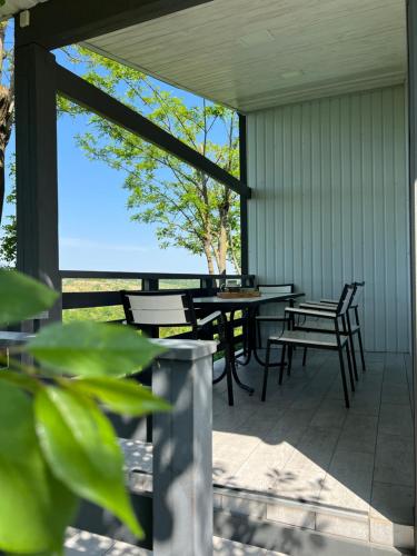 a patio with tables and chairs and a view of the ocean at Сottage "Family Estate" in Kamianets-Podilskyi