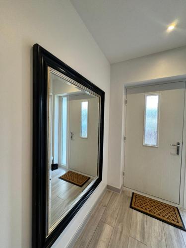 a large mirror on a wall next to a door at Stunning Ensuite Room in Beckenham