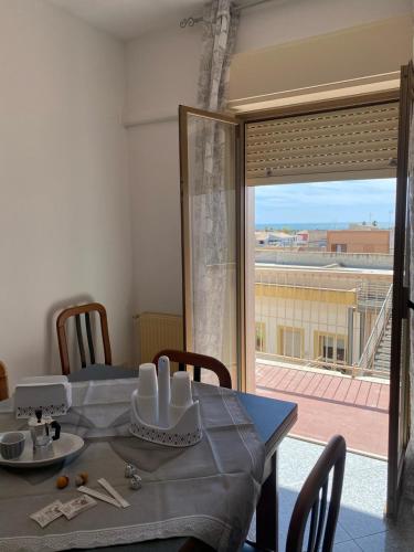 mesa de comedor con vistas a un balcón en casa vacanze Ivan 2, en Marsala