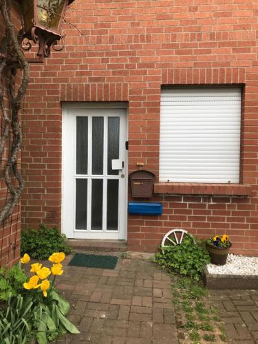 a brick house with a white door and two windows at Ferienwohnung Landidylle in Friedrichshausen