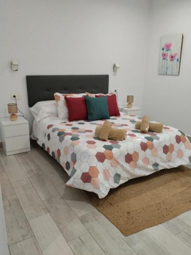 a bedroom with a large bed with colorful pillows at LA BRISA in Cádiz