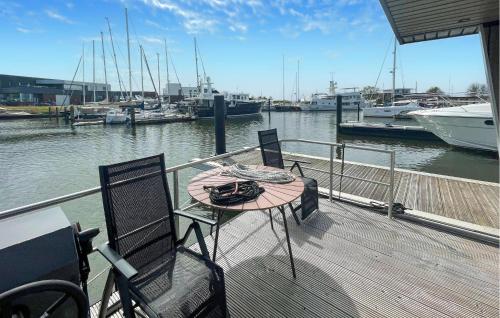 a table and chairs on a dock with boats in the water at 2 Bedroom Lovely Ship In Hellevoetsluis in Hellevoetsluis