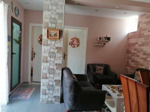 uma sala de estar com duas cadeiras e uma parede de pedra em Appartement meublée f3 em Alger