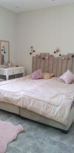 a bedroom with a large white bed and a mirror at Appartement meublée f3 in Alger