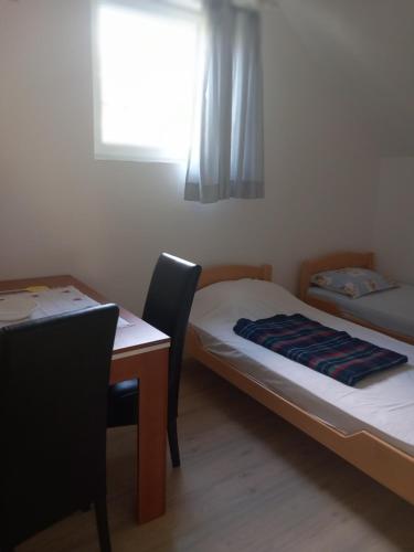 een kamer met 2 bedden, een tafel en een raam bij Studio Vrujci 2 in Rakari