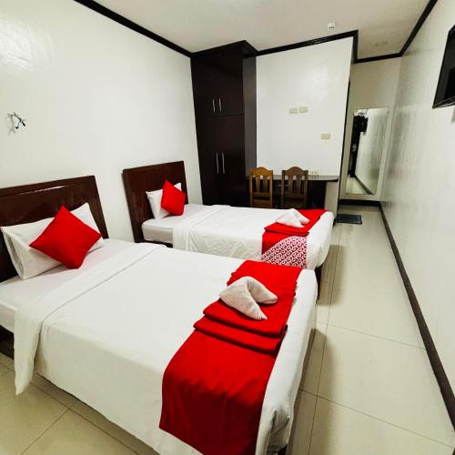 Habitación de hotel con 2 camas con almohadas rojas en Offshore Hotel en General Santos