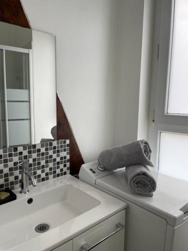 - une cuisine blanche avec un évier et un miroir dans l'établissement Havre de paix / 10 minutes de Paris-Orly, à Villejuif