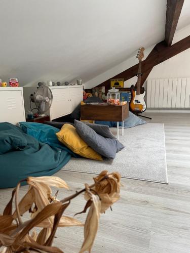 - un salon avec un lit et une guitare dans l'établissement Havre de paix / 10 minutes de Paris-Orly, à Villejuif