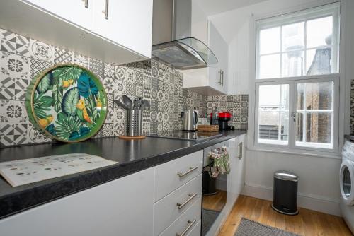 een keuken met een wastafel en een bord op het aanrecht bij Cosy Central London Flat - Covent Garden - Oxford Street in Londen