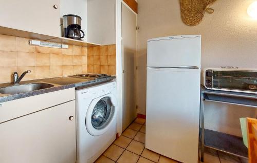 La cuisine est équipée d'un réfrigérateur blanc et d'un lave-vaisselle. dans l'établissement 2 Bedroom Beautiful Home In Les Mathes, aux Mathes