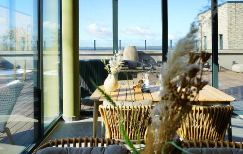 a patio with a table and chairs and windows at Gorgeous Home In Lembruchdümmer See in Lembruch