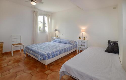 フュリアニにあるLovely Apartment In Furiani With Kitchenのベッドルーム1室(ベッド2台、椅子、窓付)