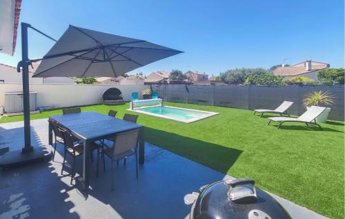 un patio avec une table et un parasol dans une cour dans l'établissement Gorgeous Home In Bassan, à Bassan