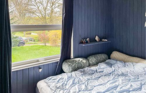 een blauwe slaapkamer met een bed en een raam bij Awesome Home In Kirke Hyllinge With Wifi in Kirke-Hyllinge