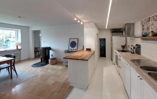 a kitchen with white cabinets and a wooden counter top at Awesome Home In Limhamn With Kitchen in Malmö