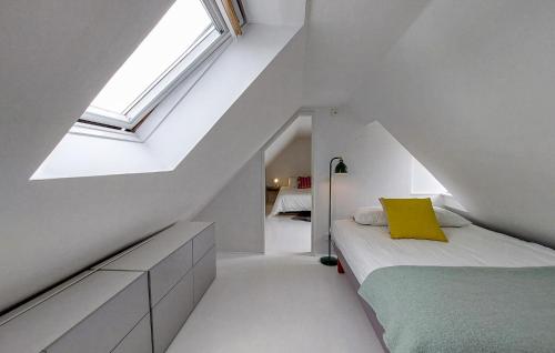 a attic bedroom with a bed and a window at Awesome Home In Limhamn With Kitchen in Malmö