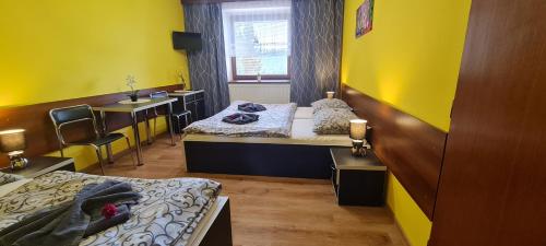 a room with two beds and a desk and a sink at Penzion na Lůkách in Horní Bečva