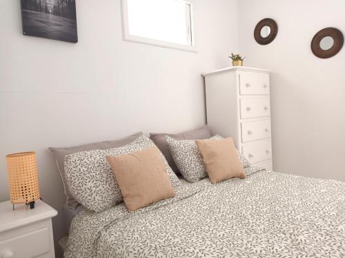a bedroom with a bed with pillows and a dresser at Amejica - Apartment with terrace and sea view in Tabaiba
