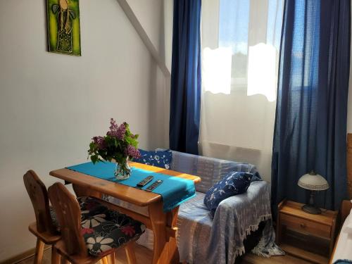 a living room with a table and a couch at Oberża Pod Kudłatym Aniołem in Cisna