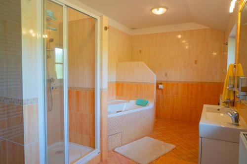 y baño con ducha, bañera y lavamanos. en Chalupa na Krakovci u Rakovníka 