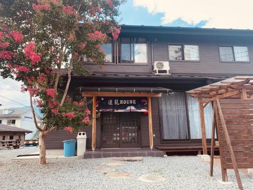 una casa con un árbol delante de ella en 道龍house, en Azagawa