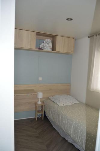 - une petite chambre avec un lit et une petite table dans l'établissement Mobile Home de Valérie 