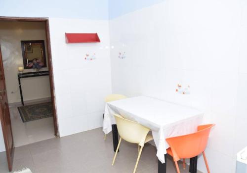 a white table and chairs in a white room at Chez Ouly in Dakar