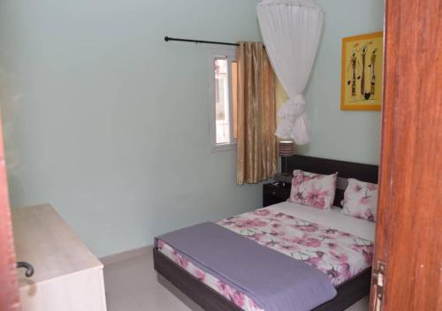 a small bedroom with a bed in a room at Chez Ouly in Dakar