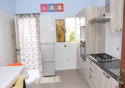 a kitchen with a white refrigerator and a stove at Chez Ouly in Dakar