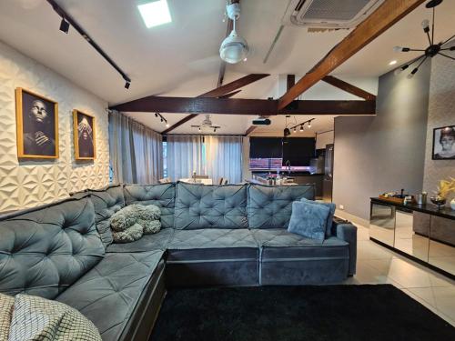 a living room with a large blue couch at Casa inteira l 7 min Alphaville in Osasco