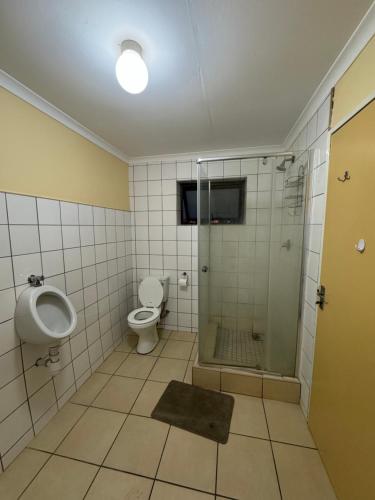 een badkamer met een douche, een toilet en een wastafel bij Ramblers Self-Catering Hostel (No Aircon/No TV/No Pool) in Windhoek