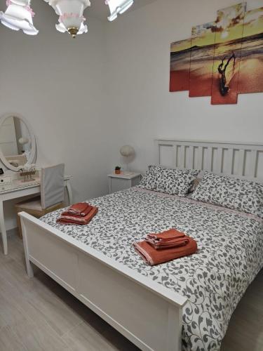 a bedroom with a bed and a desk and a mirror at Holiday house Chiara in Giardini Naxos