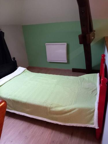 - un petit lit dans une chambre aux murs verts dans l'établissement demeure de la vielle tour, à Rancourt