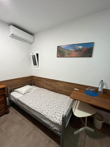 a bed in a room with a desk and a bed sidx sidx sidx at Cozy room next to el prat airport in El Prat de Llobregat