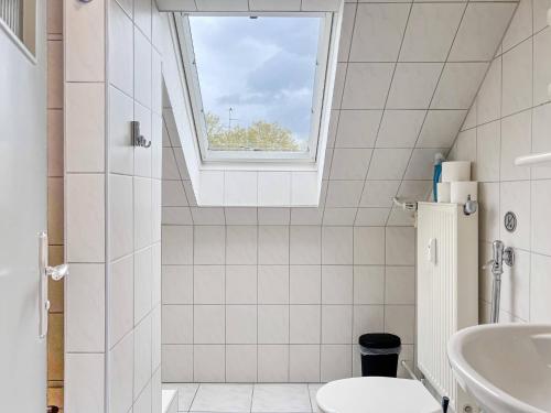 een badkamer met een wastafel, een toilet en een raam bij T&K Apartments - Krefeld Zentrum - 1 and 2 room Apartment 20min to Fair DUS in Krefeld