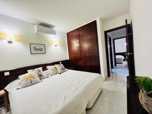 1 dormitorio con 1 cama con sábanas y almohadas blancas en Ancora Salou primera línea, en Salou