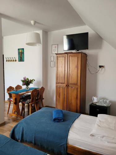 a bedroom with a bed and a dining room table at Oberża Pod Kudłatym Aniołem in Cisna