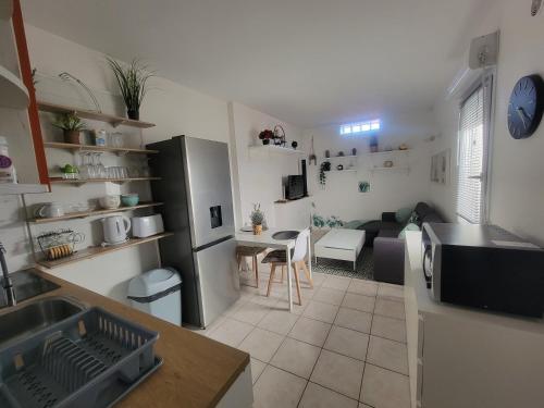 Il dispose d'une cuisine et d'un salon avec un réfrigérateur et une table. dans l'établissement Jolie dépendance avec terrasse privée et jacuzzi, à Marseille
