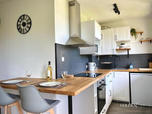 a kitchen with white cabinets and a wooden counter top at Le Golden View - Vue Imprenable & Parking Gratuit in Chambéry
