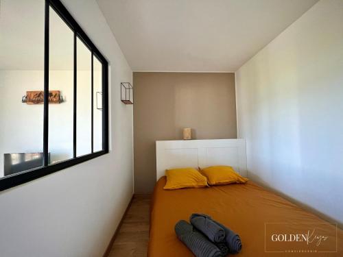 - un petit lit dans une chambre avec fenêtre dans l'établissement Le Golden View - Vue Imprenable & Parking Gratuit, à Chambéry