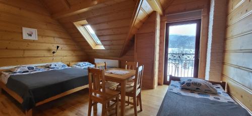 a room with two beds and a table and a window at Grazynka in Zakopane