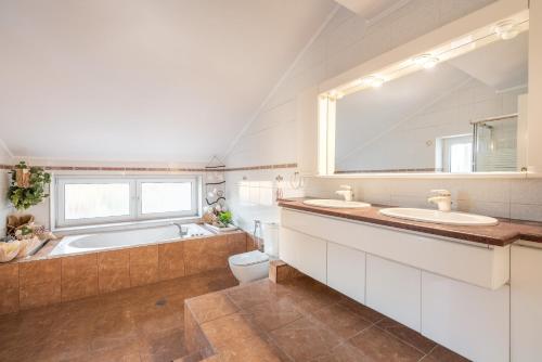 a bathroom with two sinks and a tub and a toilet at Artzy Villa in Rhodes Town