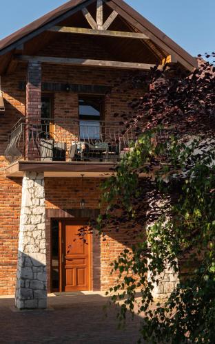 a brick building with a balcony and a door at Agroturystyka Pod Strażnicą in Lutowiec