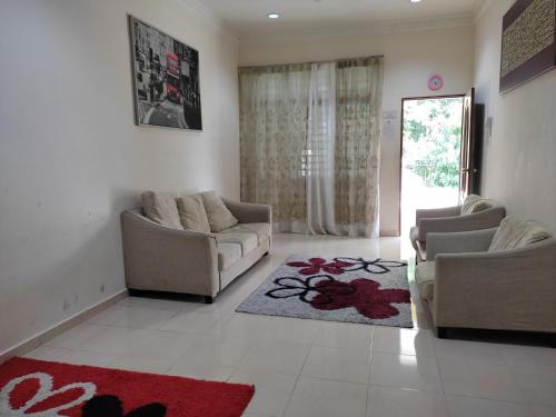- un salon avec deux canapés et un tapis rouge dans l'établissement Homestay Al amin 2, à Kampong Sura Tengah
