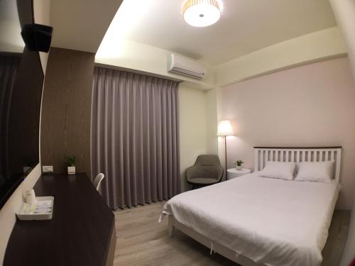 une chambre d'hôtel avec un lit et une chaise dans l'établissement Sway Hotel - Fenjia, à Taichung