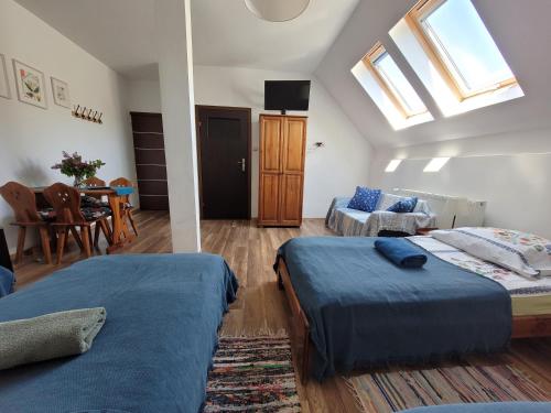 a bedroom with two beds and a living room at Oberża Pod Kudłatym Aniołem in Cisna